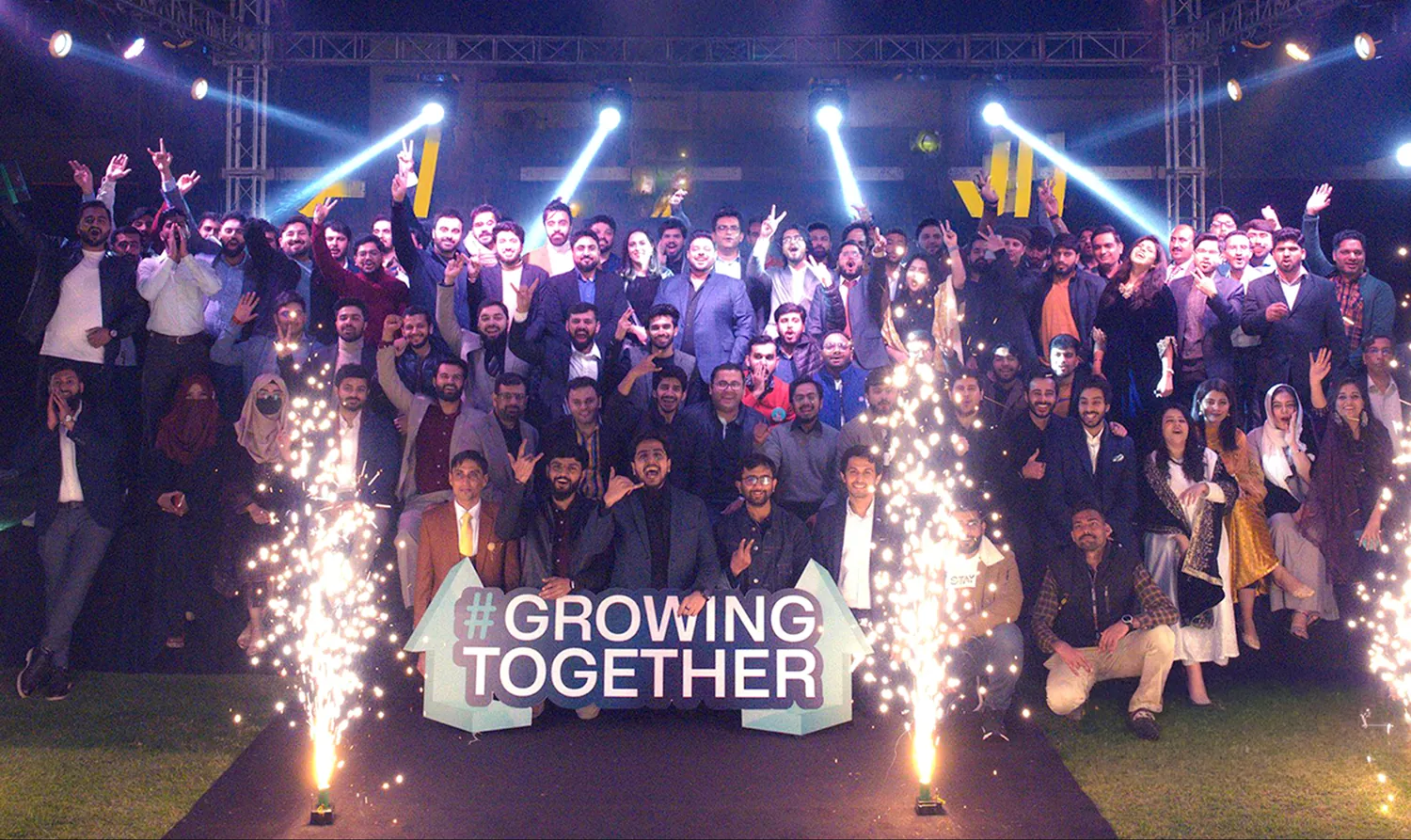 Codedistrict team celebrating together under the “Growing Together” banner at the annual gathering